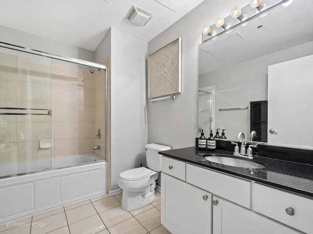 bathroom with visible vents, toilet, enclosed tub / shower combo, tile patterned flooring, and vanity