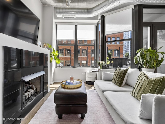 living area with a healthy amount of sunlight, a fireplace, and wood finished floors