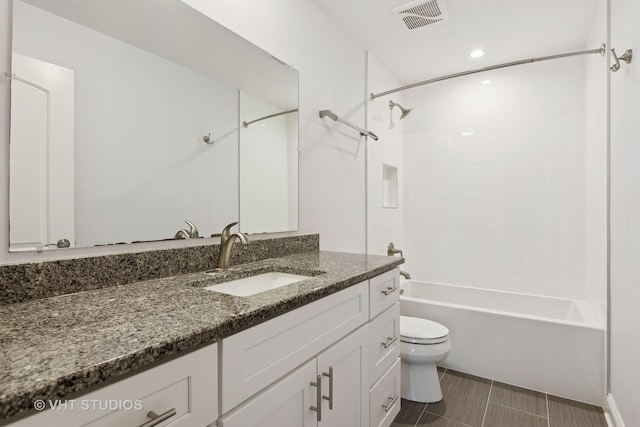 full bathroom featuring tiled shower / bath, vanity, and toilet