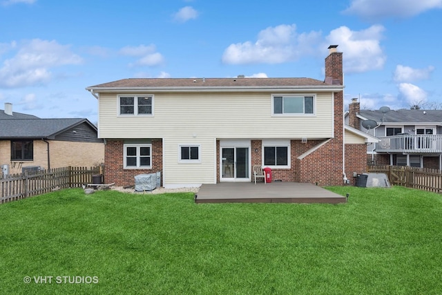 rear view of house featuring a yard and a deck