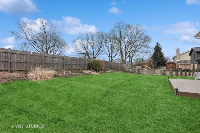 view of yard featuring a wooden deck and a playground