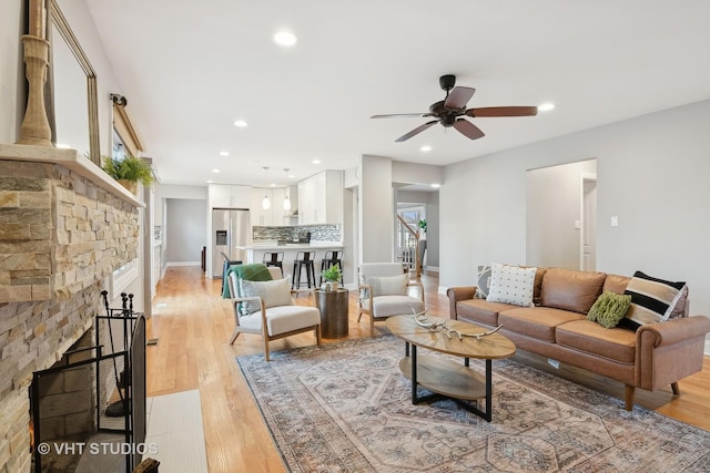 living room featuring ceiling fan and light wood-type flooring