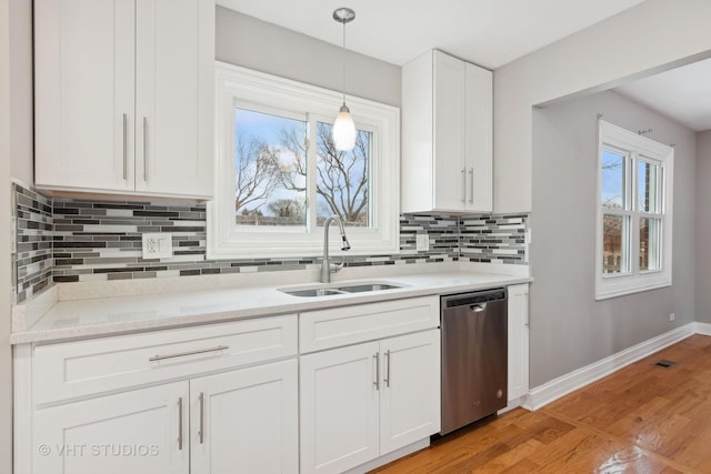 kitchen with sink, white cabinetry, decorative light fixtures, dishwasher, and light hardwood / wood-style floors