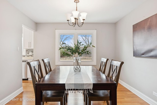 dining area featuring light wood-type flooring and a chandelier