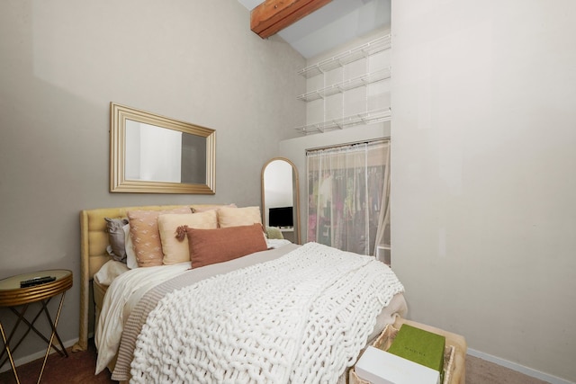 carpeted bedroom featuring beamed ceiling and high vaulted ceiling