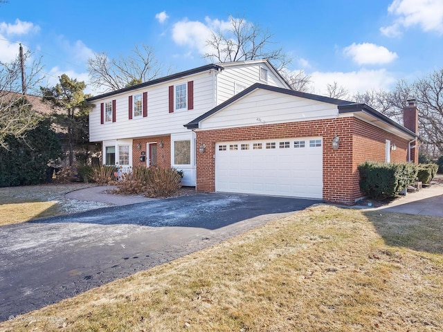 view of front facade with a garage, a chimney, aphalt driveway, and brick siding