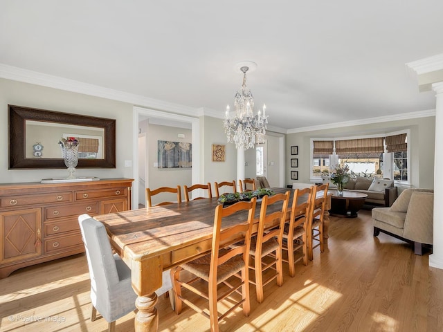 dining room with ornamental molding, light wood-type flooring, and a healthy amount of sunlight