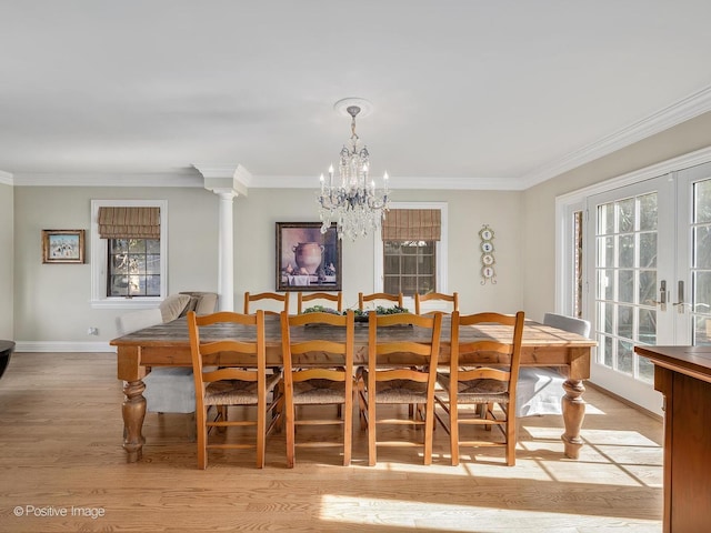 dining area with light wood finished floors, baseboards, a chandelier, and crown molding