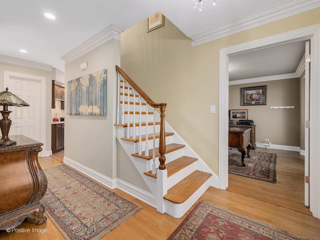 staircase featuring ornamental molding, recessed lighting, baseboards, and wood finished floors