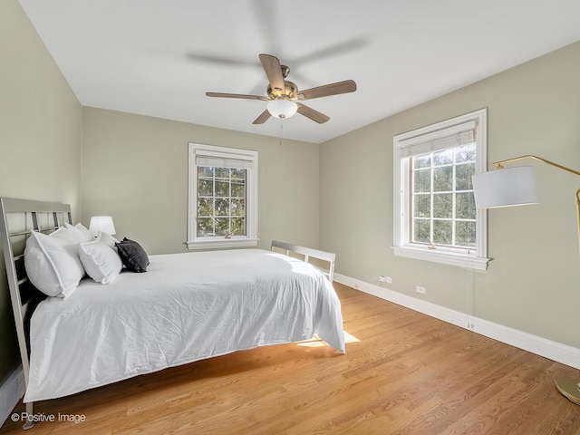 bedroom featuring wood finished floors, a ceiling fan, and baseboards