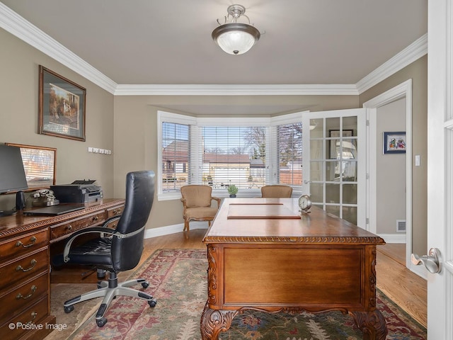 home office featuring light wood finished floors, visible vents, baseboards, and crown molding