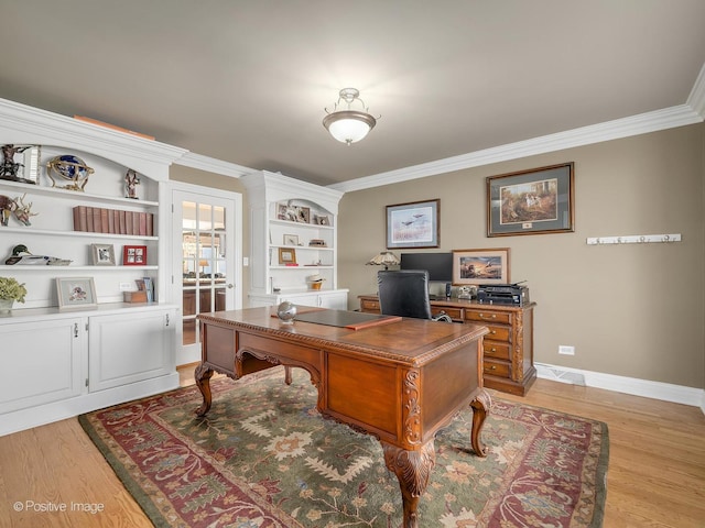 office space featuring ornamental molding, light wood-type flooring, visible vents, and baseboards