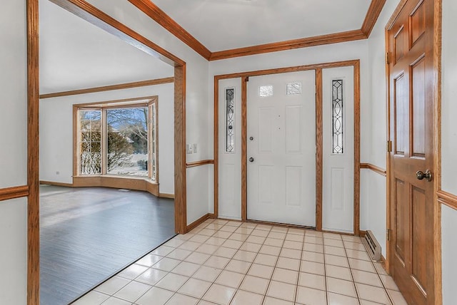 entrance foyer with crown molding and light tile patterned floors