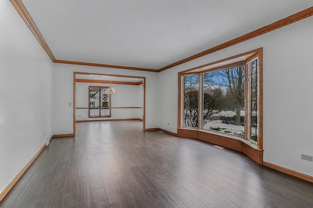 unfurnished room with visible vents, crown molding, baseboards, and wood finished floors