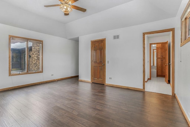 empty room with a ceiling fan, visible vents, baseboards, and wood finished floors