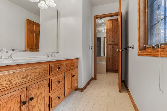 full bath with double vanity, a sink, and baseboards