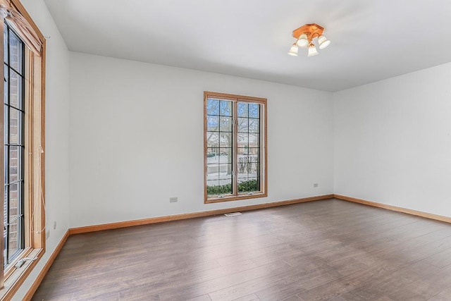 unfurnished room with baseboards and wood finished floors