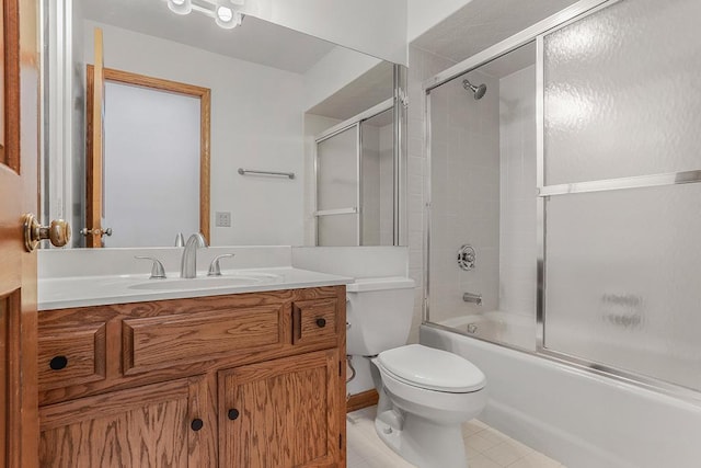 bathroom with toilet, vanity, combined bath / shower with glass door, and tile patterned floors