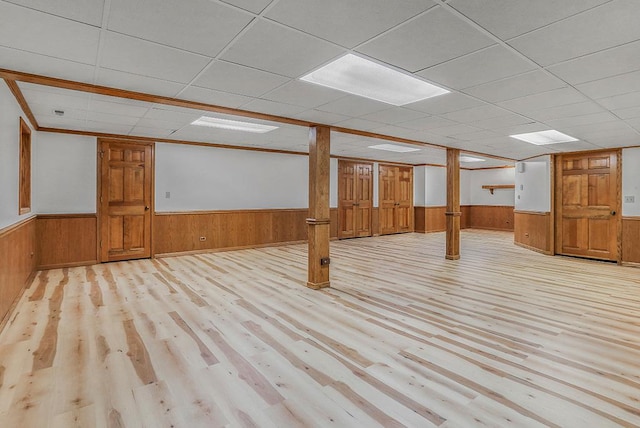 finished basement featuring a wainscoted wall and wood finished floors