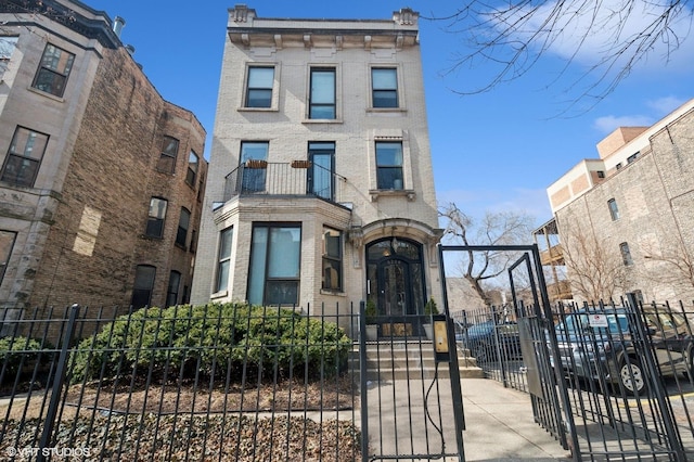 italianate house featuring brick siding and a fenced front yard