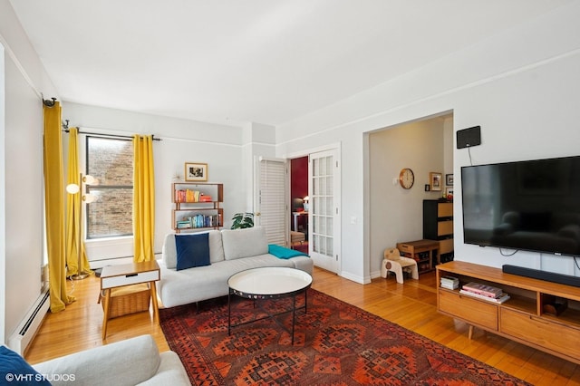 living room with a baseboard heating unit, baseboard heating, and wood finished floors