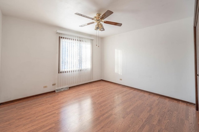 spare room featuring wood-type flooring and ceiling fan