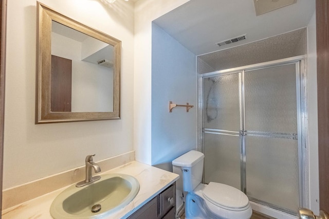 bathroom featuring vanity, an enclosed shower, and toilet