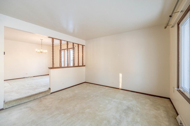 empty room featuring a baseboard radiator, a chandelier, and carpet floors