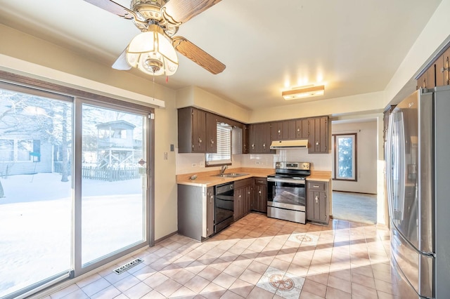 kitchen featuring a healthy amount of sunlight, appliances with stainless steel finishes, sink, and backsplash