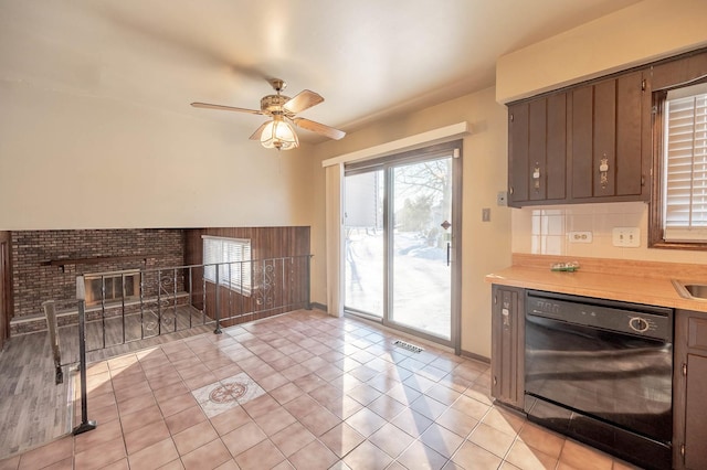 living room featuring a brick fireplace, ceiling fan, and light tile patterned flooring