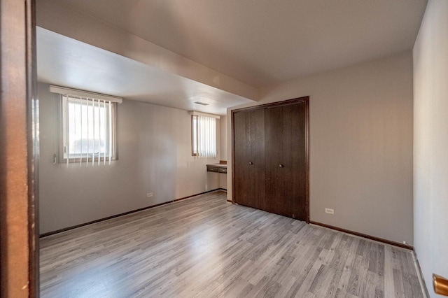 unfurnished bedroom featuring light hardwood / wood-style floors and a closet