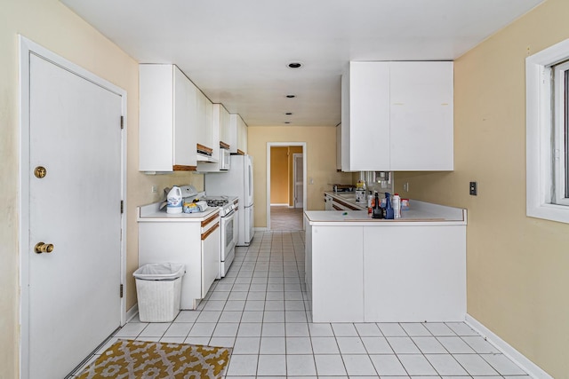 kitchen featuring white cabinetry, white gas range oven, and light tile patterned flooring