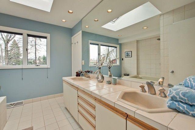 bathroom with separate shower and tub, tile patterned floors, a skylight, and vanity