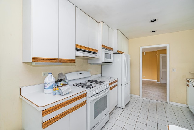 kitchen featuring white cabinetry, white appliances, and light tile patterned flooring