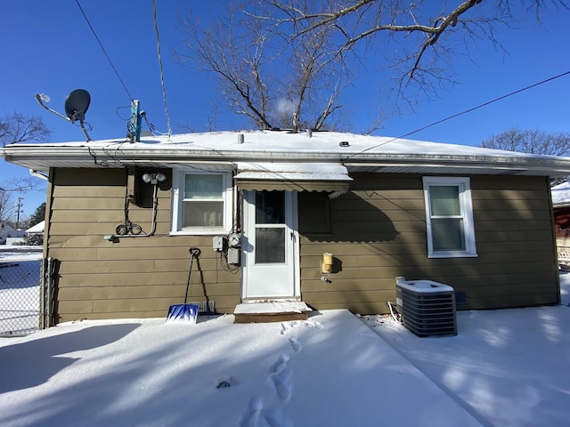 snow covered back of property with central AC