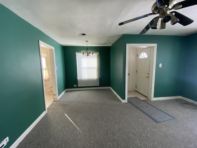 interior space featuring carpet flooring and ceiling fan with notable chandelier