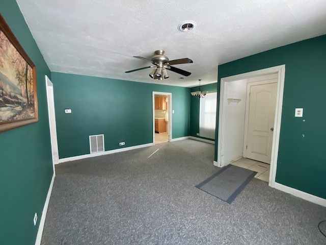 unfurnished room featuring ceiling fan with notable chandelier and a textured ceiling