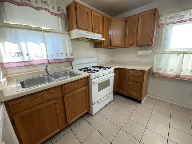 kitchen with white range with gas cooktop, sink, and light tile patterned floors