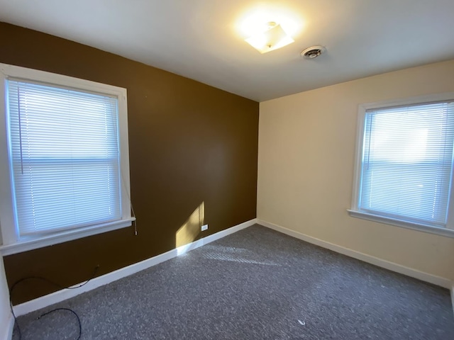 empty room featuring dark colored carpet