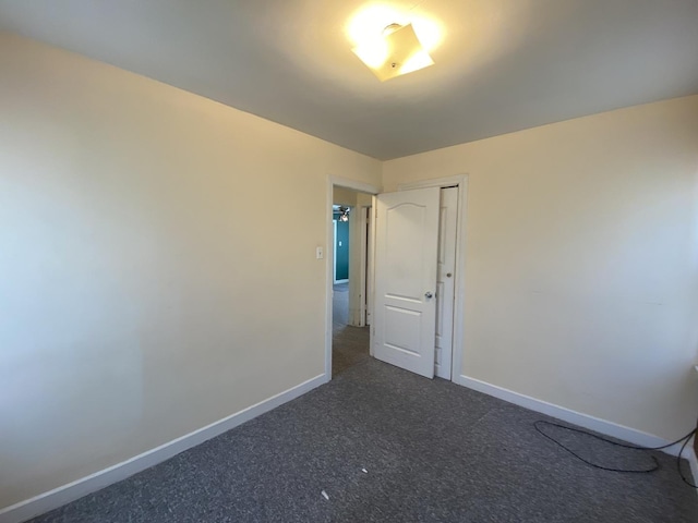 spare room featuring dark carpet