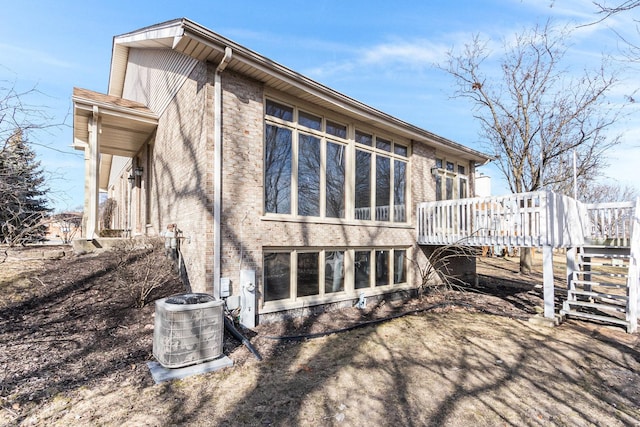 rear view of house featuring a wooden deck and central AC unit