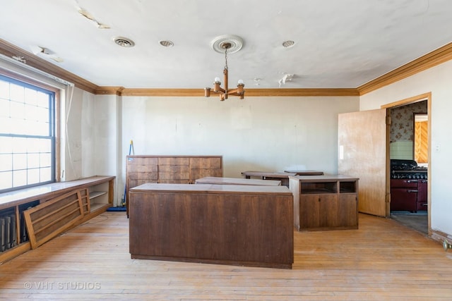 kitchen featuring ornamental molding, a center island, an inviting chandelier, and light hardwood / wood-style floors