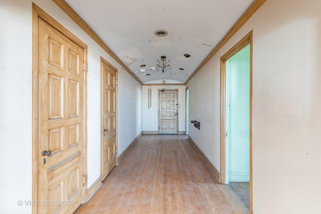 corridor featuring crown molding and light wood-type flooring