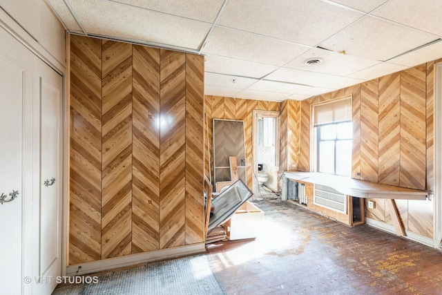 miscellaneous room featuring hardwood / wood-style floors, a drop ceiling, and wooden walls