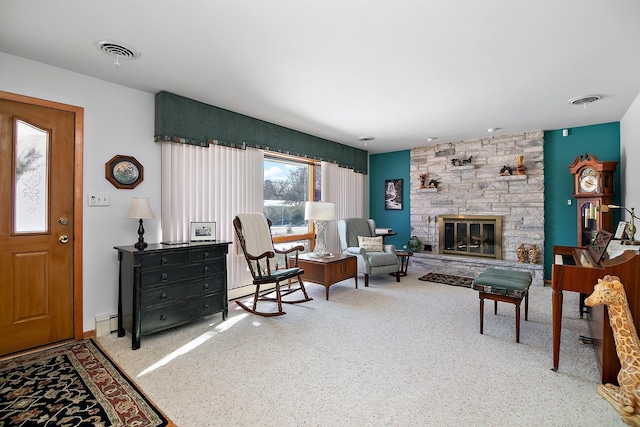 living room with carpet floors, a stone fireplace, and a baseboard heating unit