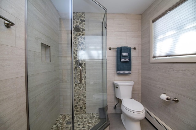 bathroom featuring tile walls, a baseboard heating unit, a shower with door, and toilet