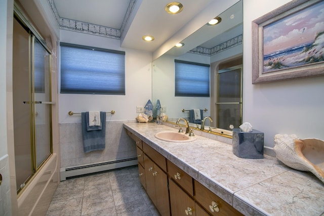 bathroom with vanity, baseboard heating, and shower / bath combination with glass door