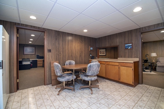 dining area featuring wooden walls and light colored carpet