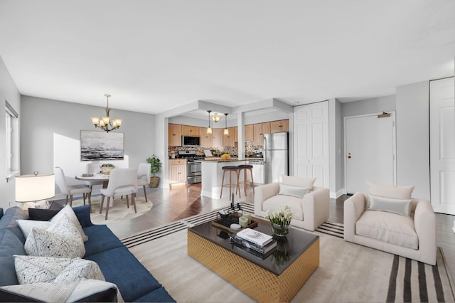 living room with an inviting chandelier and light hardwood / wood-style floors