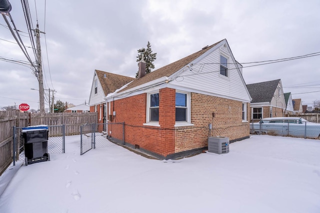 snow covered property with central air condition unit